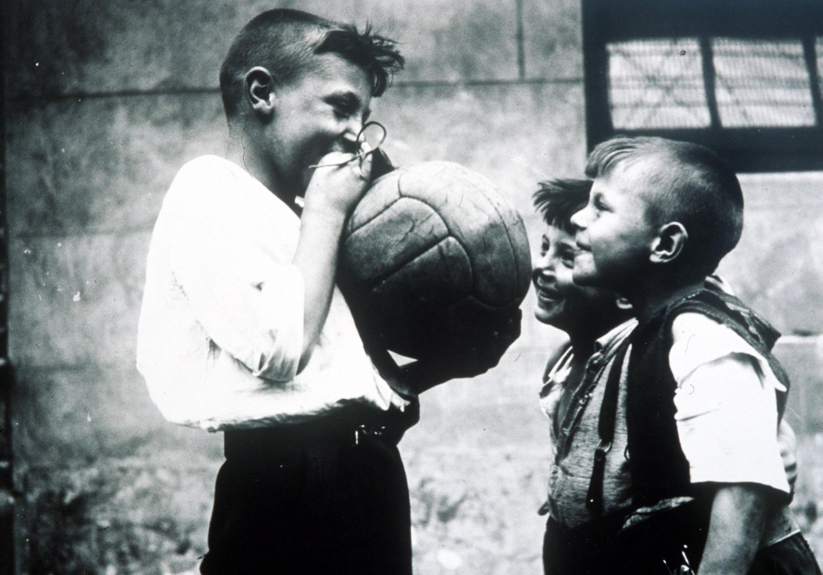 Meninos jogando futebol nos anos 50